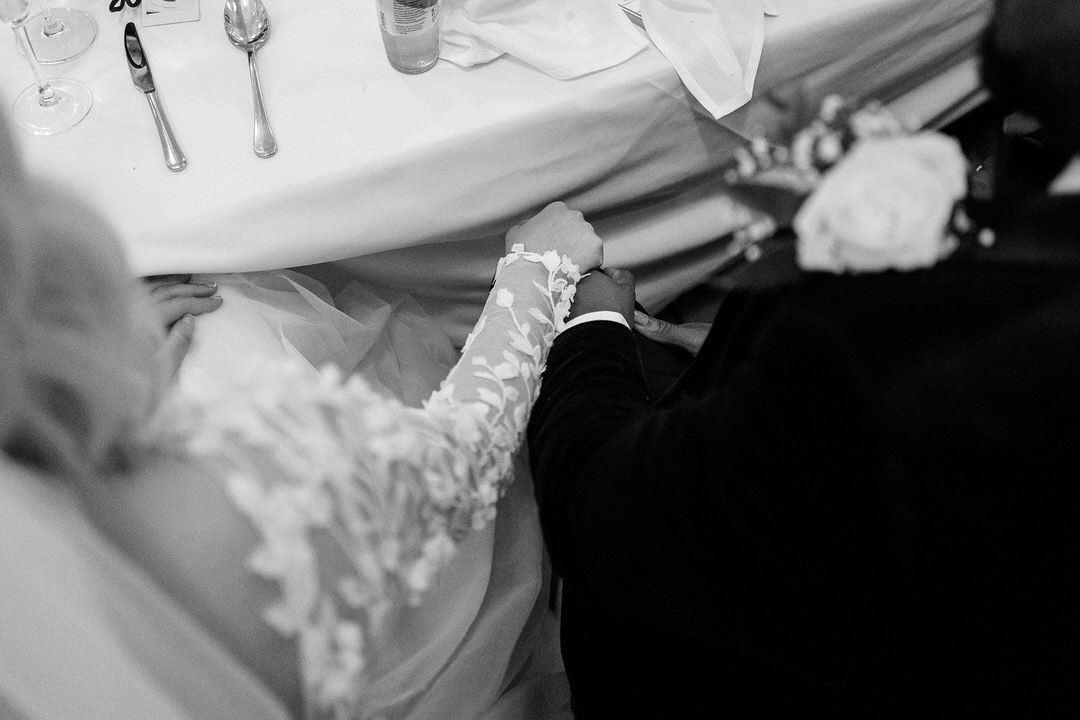 Guests enjoying a lively celebration at an elegant indoor reception with arched windows and warm lighting.