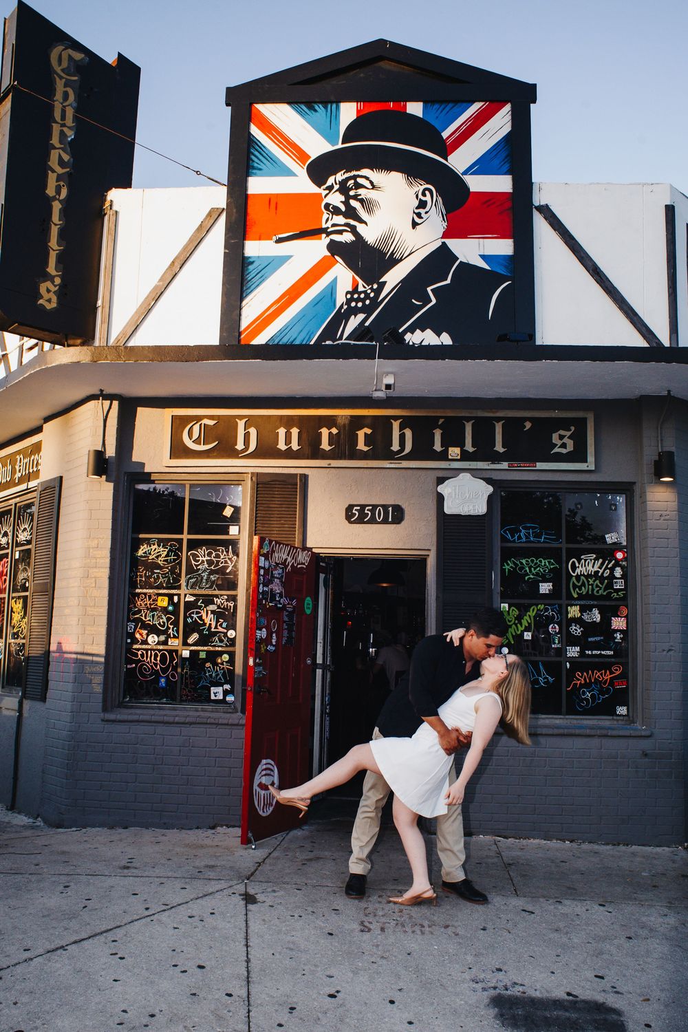 A sequence of four photos showing a breakdancer performing a windmill move on a sidewalk outside a bar with Churchill artwork.
