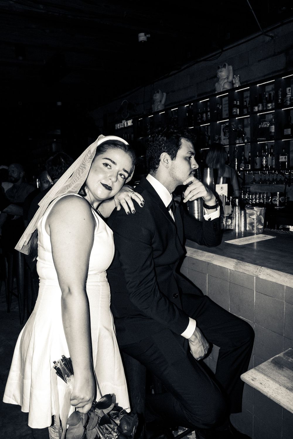 Black and white photo sequence showing a couple at a bar counter, progressing through intimate moments in dim lighting.