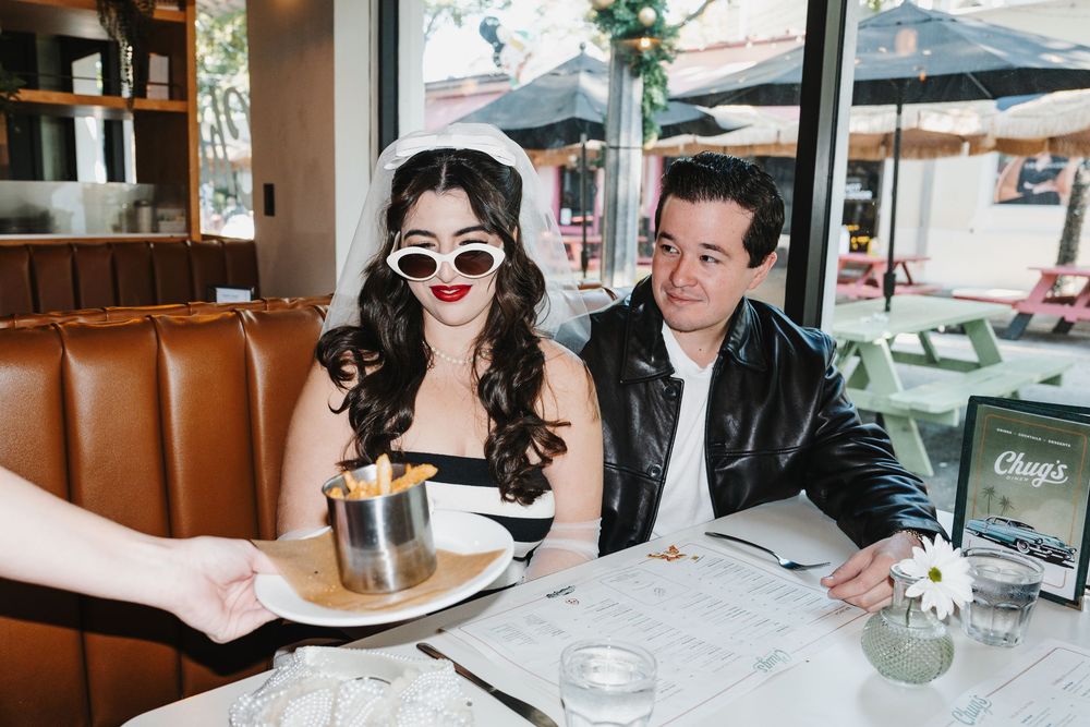 A couple sits at a restaurant table enjoying drinks and conversation during a casual dining experience.