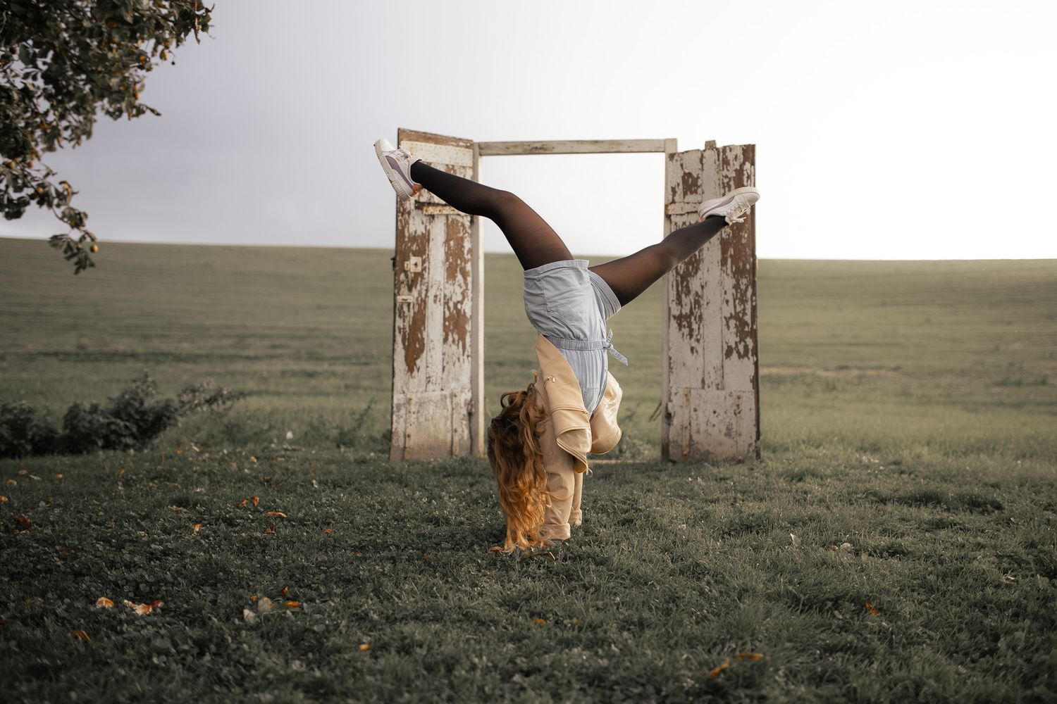 Petite fille faisant une figure de danse moderne devant la porte de Rennemoulin dans les yvelines