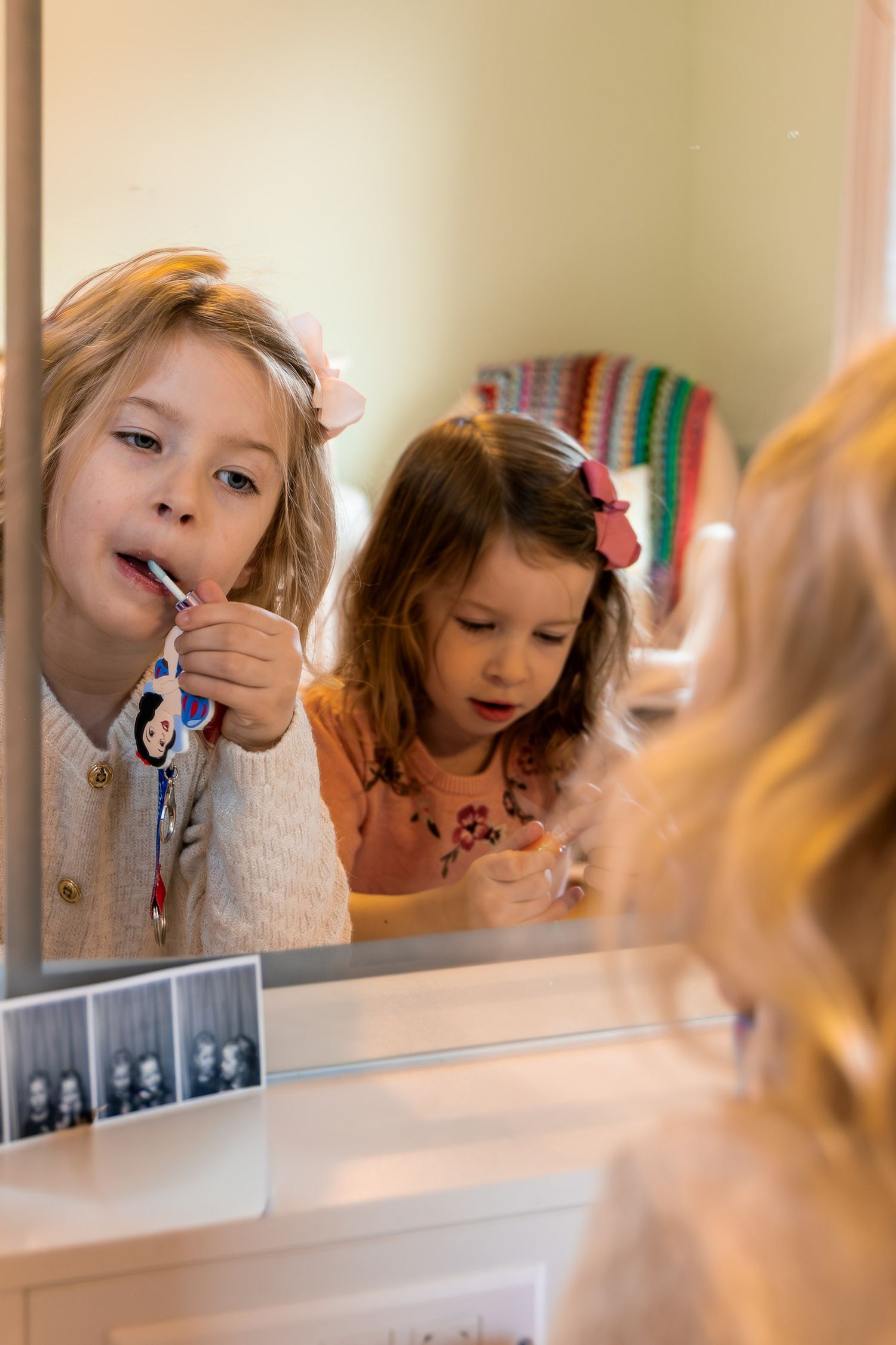 Children brushing teeth together at bathroom mirror in morning routine.