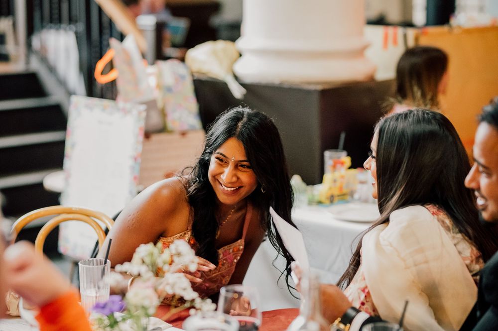 A group of people enjoying a meal together at a restaurant table filled with various dishes and drinks.
