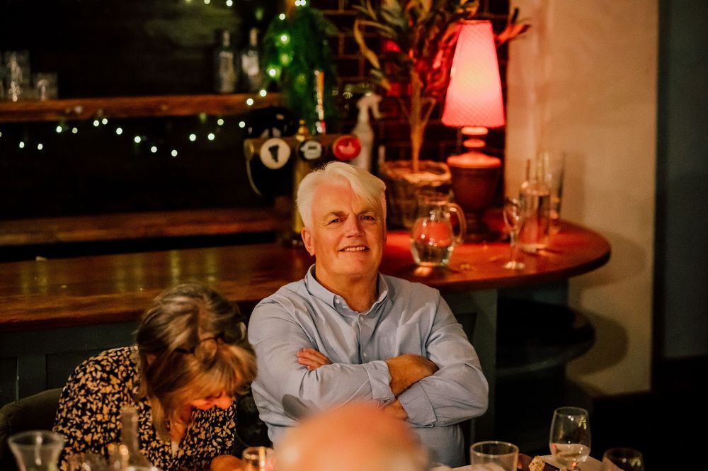 A dimly lit restaurant interior with warm lighting and cozy table settings creates an intimate dining atmosphere.