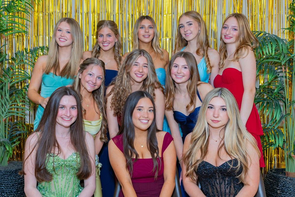 Teenage girls in formal dresses posing together in front of a gold tinsel backdrop at a pre prom event photographed in Sudbury, MA.