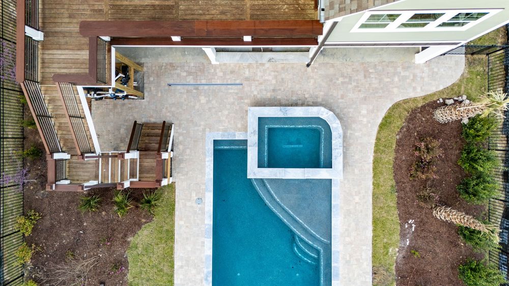 Aerial view of modern swimming pools and backyard landscaping designs in residential neighborhoods.