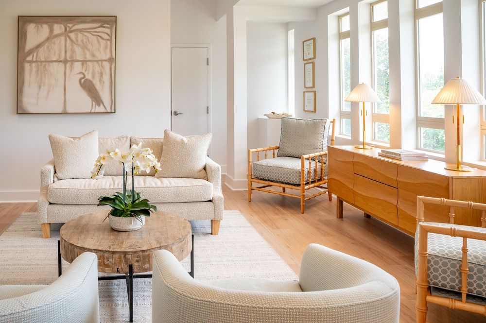 A bright minimalist living room interior with white walls, natural light, and modern Scandinavian-style furniture.