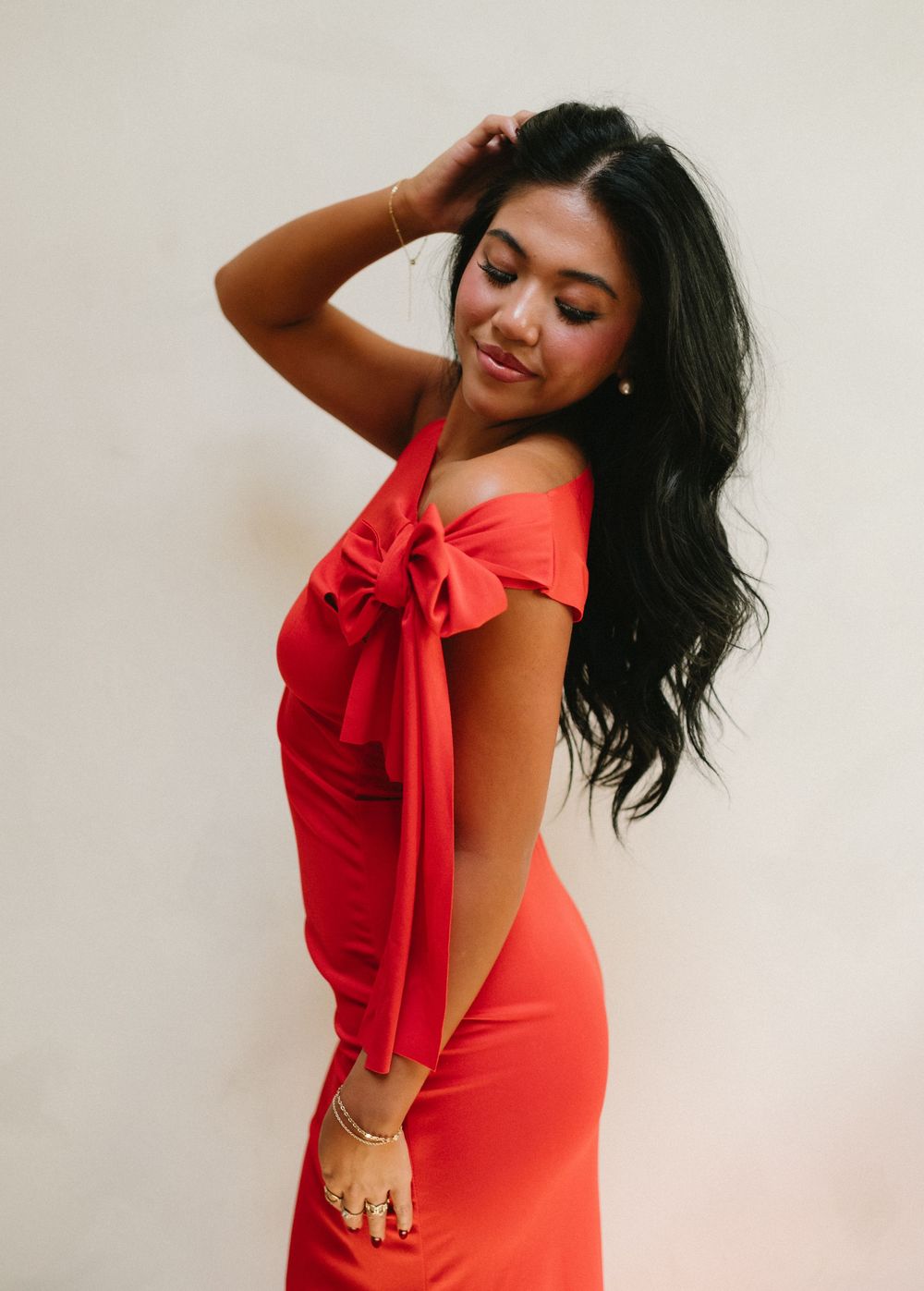 Four fashion poses in a red dress against a light background showing movement and style in a photo series.