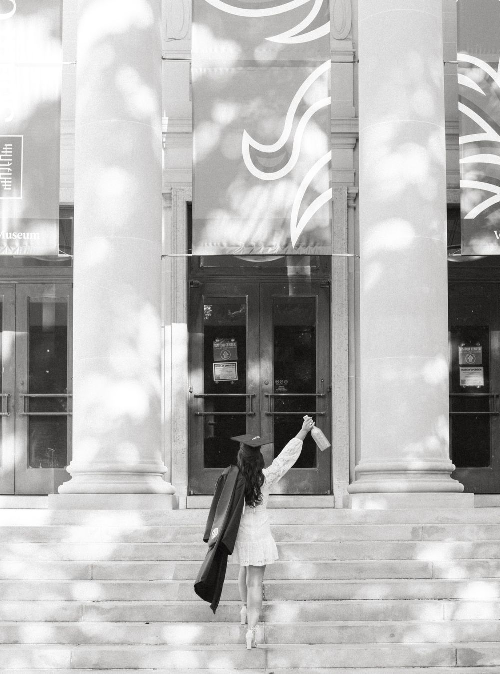 Black and white sequence showing someone walking behind white columns casting dramatic shadows.
