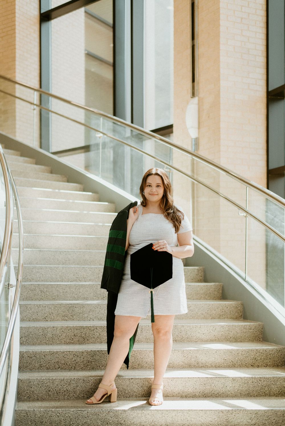 A panoramic view of a person sitting on white stone stairs in natural lighting from nearby windows.