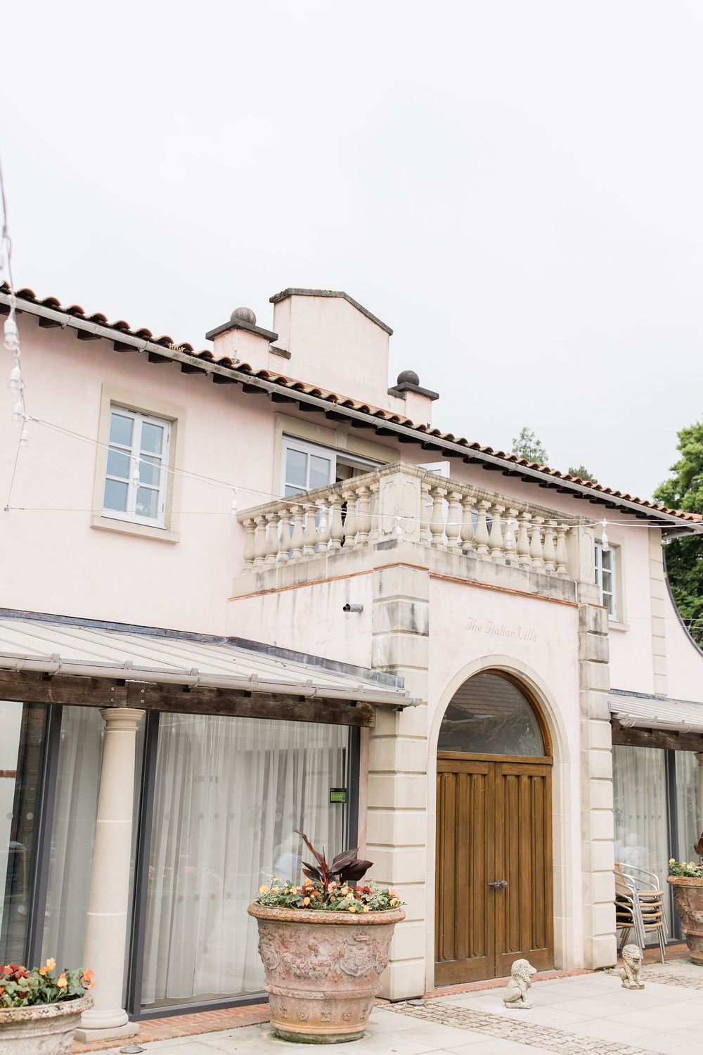 Mediterranean style villa exterior with arched doorways and stone columns against pink stucco walls at Italian Villa in Dorset