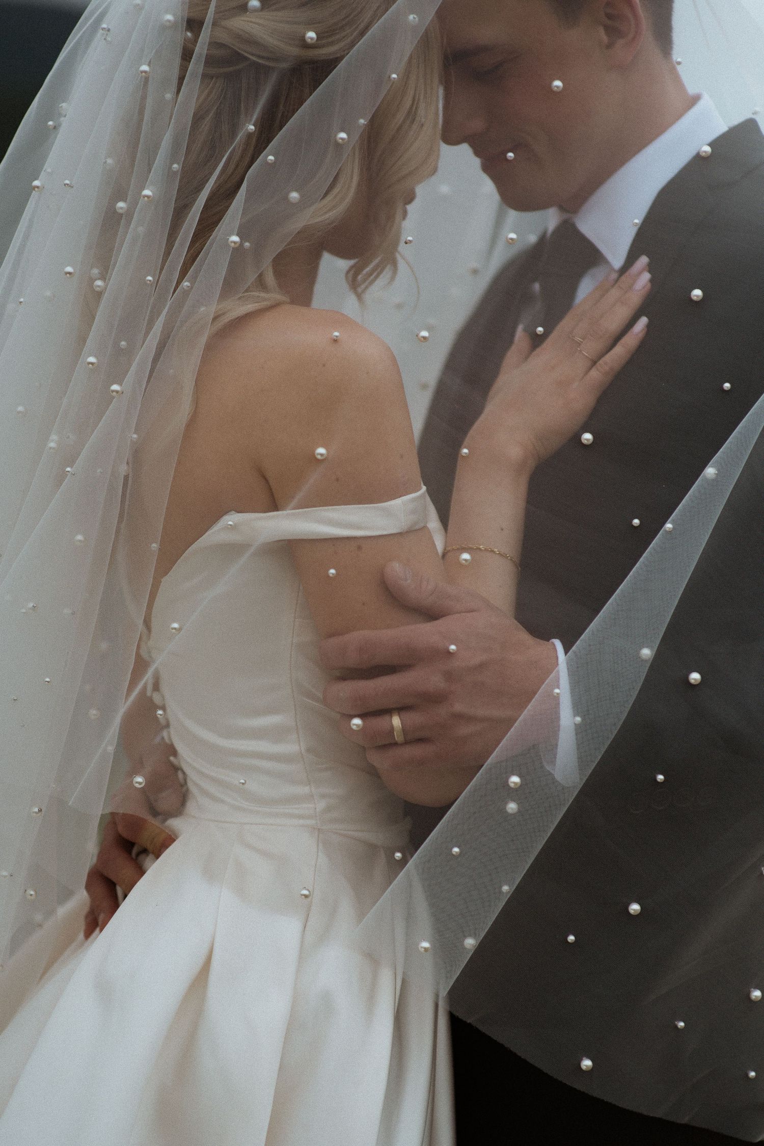 bride and groom with veil over heads