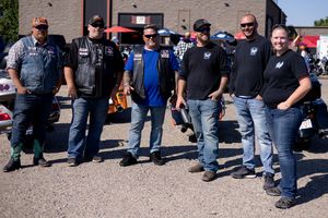 A crowd of motorcycle enthusiasts gathered outside a building for a group event or rally.