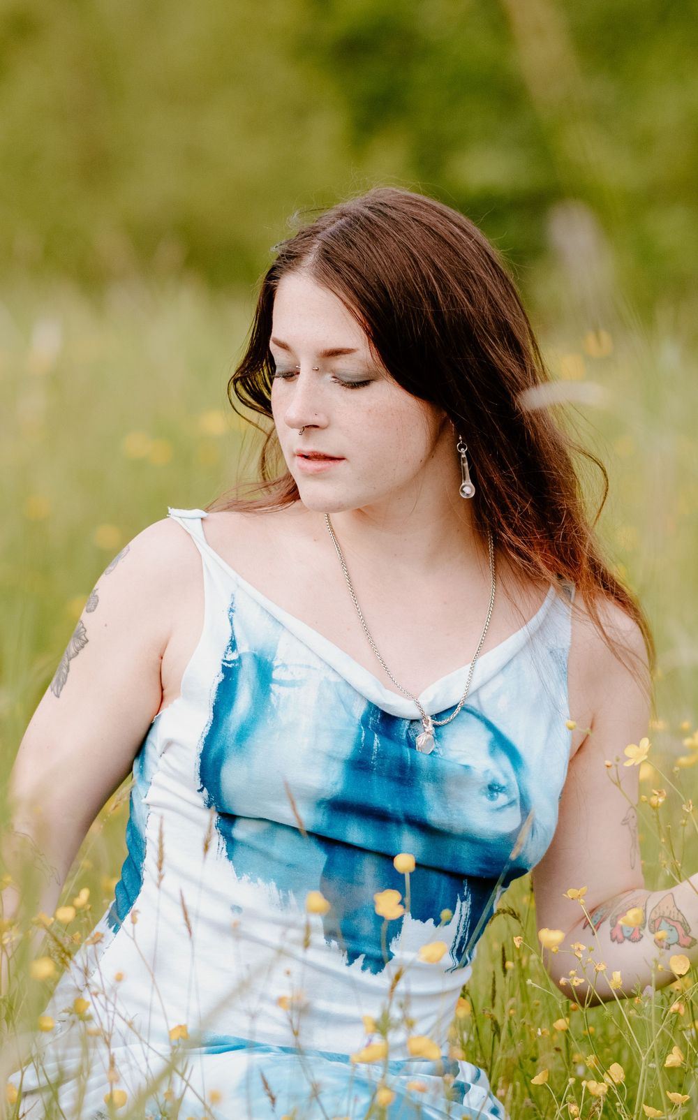 Ethereal portrait series in a wildflower field with blue and white flowing dress.