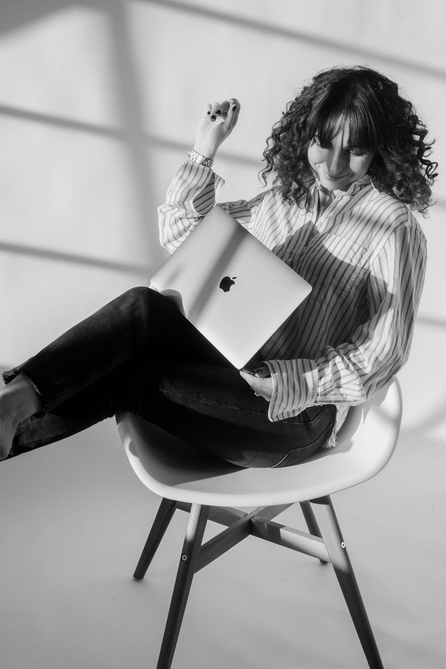 a Stockholm event photographer sitting in a chair in a photo studio, holding her laptop