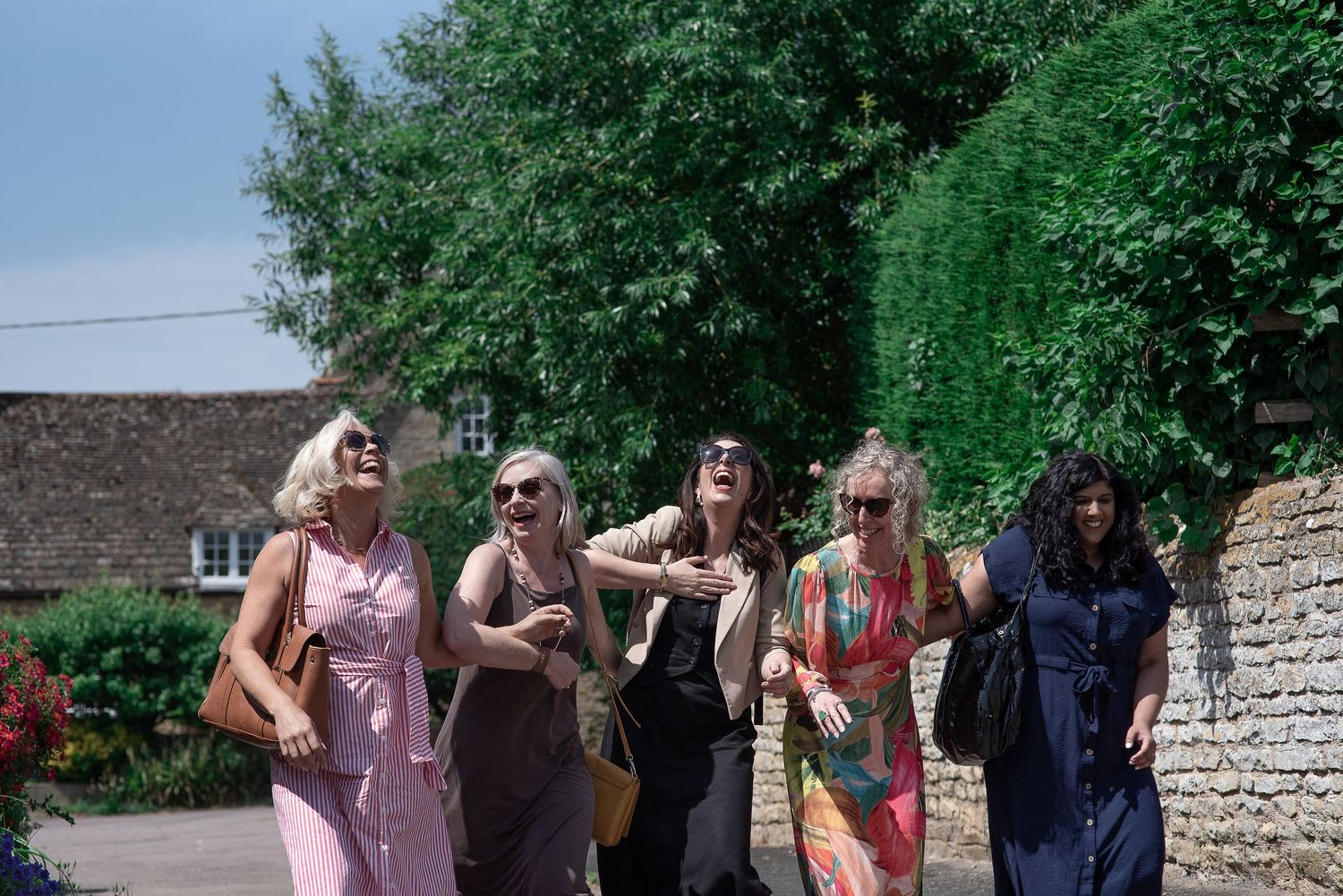 Female entrepreneurs in a personal brand photoshoot walking in a village in Northamptonshire.