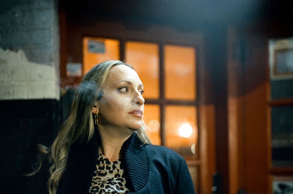 An artistic indoor portrait with moody lighting and animal print detail.