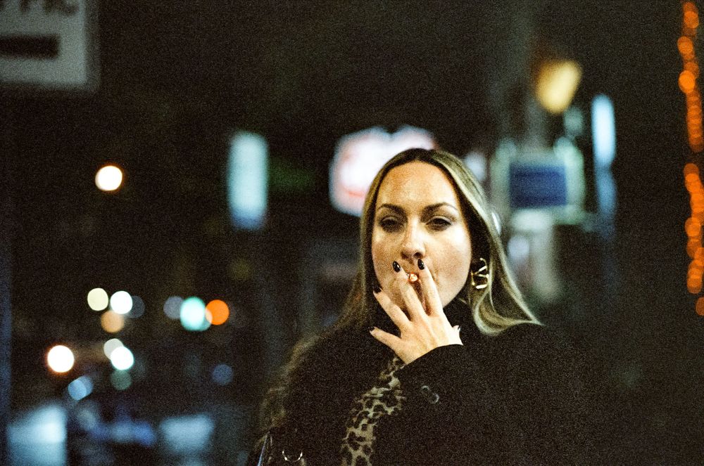 A nighttime street portrait with cinematic lighting and dark clothing.