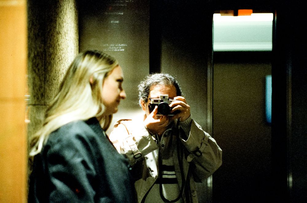 Someone taking a photograph in a dimly lit indoor space.