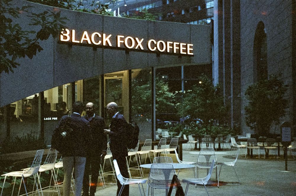 Black Fox Coffee storefront with outdoor seating area and customers.