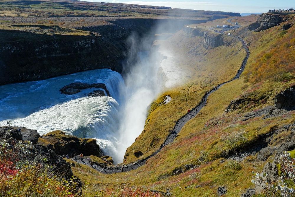 Powerful Gullfoss waterfall cascades dramatically through rocky canyon in Iceland's golden circle.