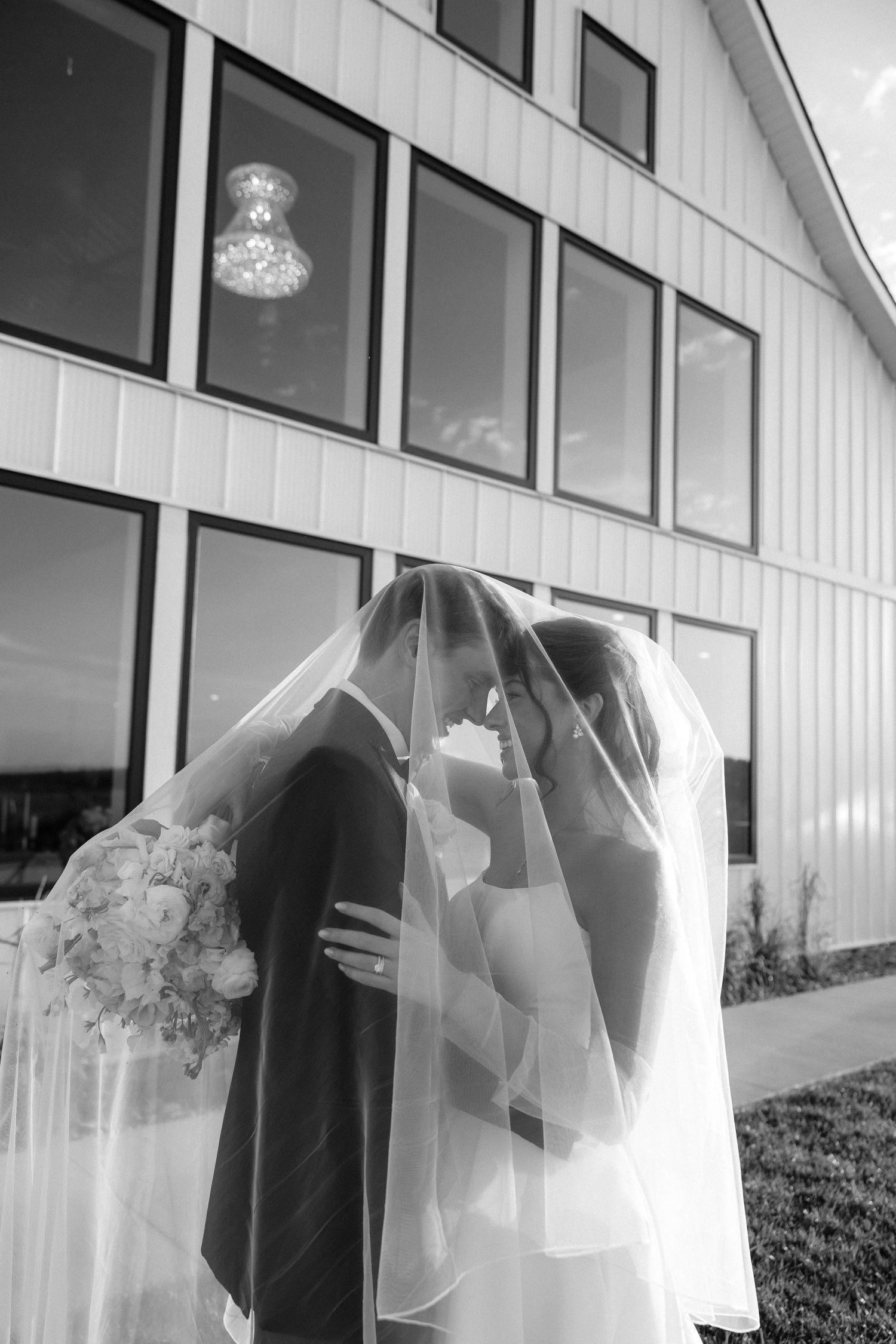 Elegant black and white wedding portrait with sleek dress and classic tuxedo.