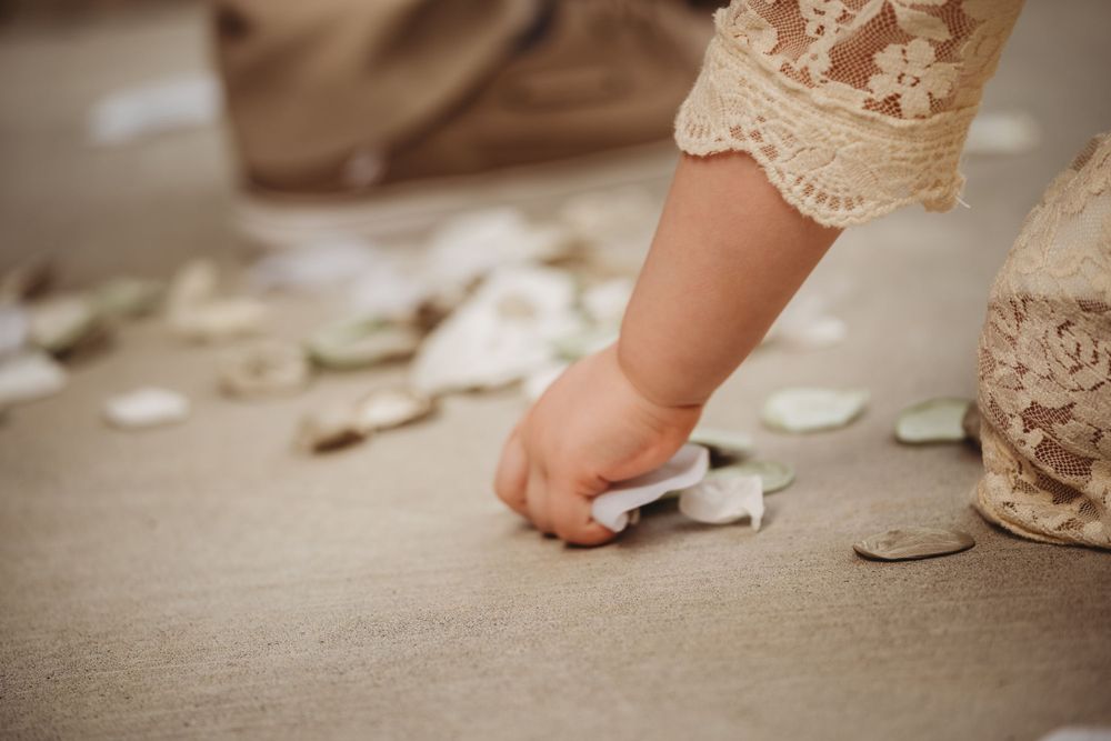small child picks up flower petals wedding Lafayette la