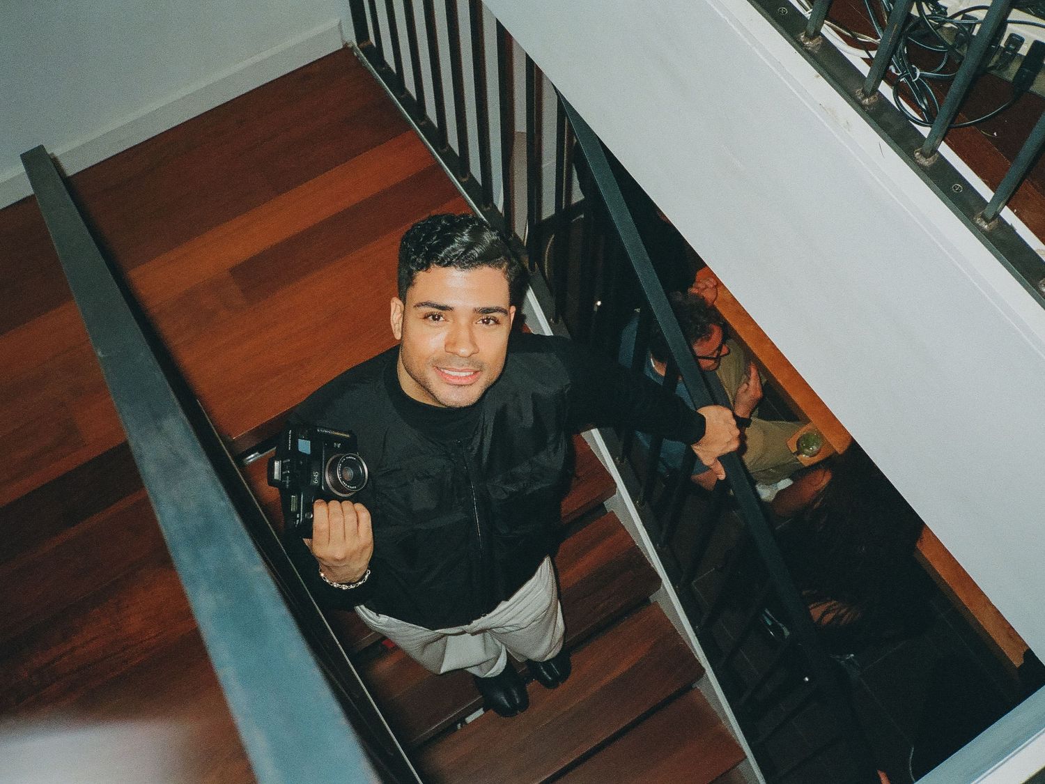 Christian Germoso on the stairs holding a camera