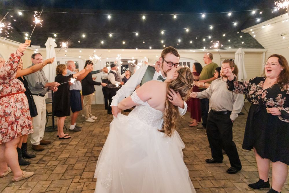 A joyful celebration with sparklers as the couple dances under twinkling lights at their wedding reception.