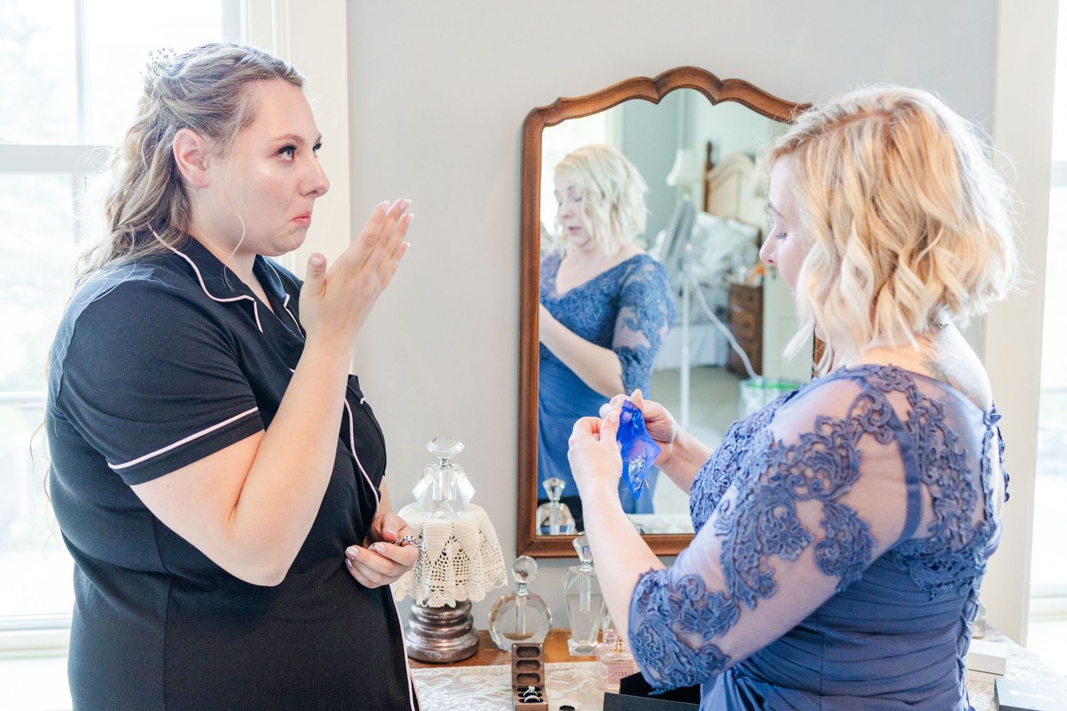 Wedding preparation scene showing styling consultation in front of a vintage mirror.