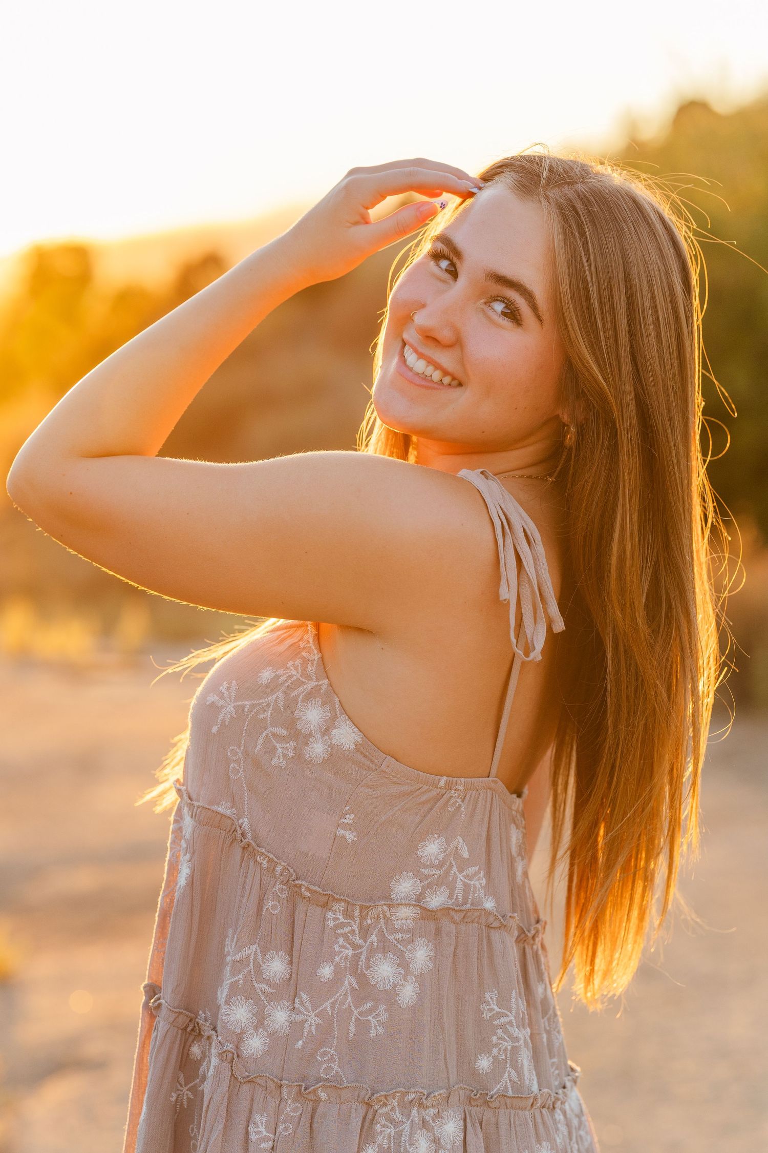 Portrait at golden hour with warm sunlight creating a dreamy backlit effect in nature.