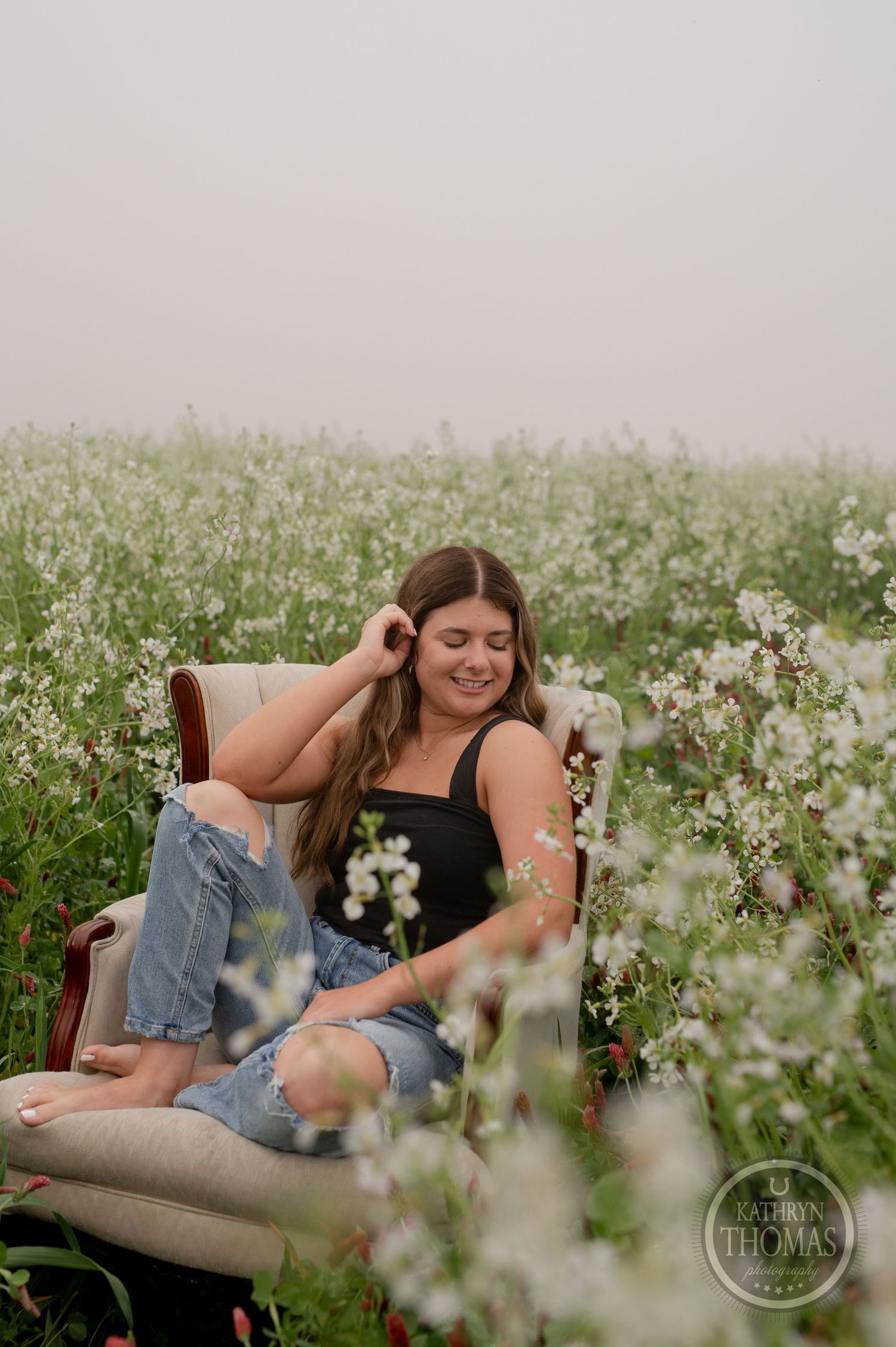 Candid moment captured in a flowering meadow with a comfortable beige armchair.