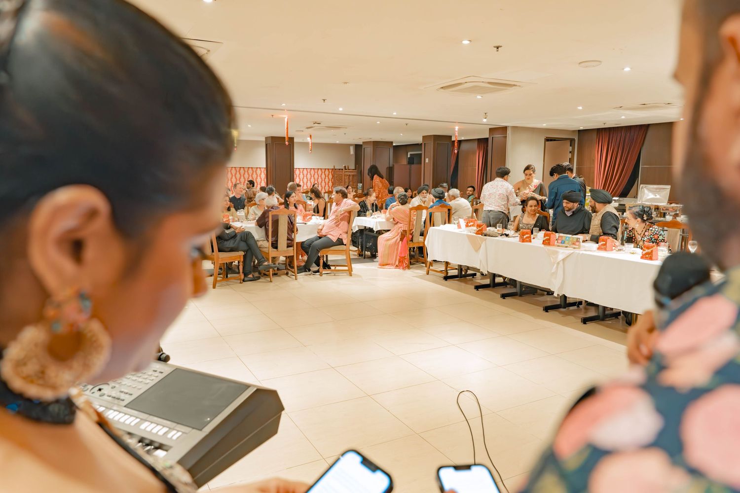 View of formal event space with tables and guests during celebration.