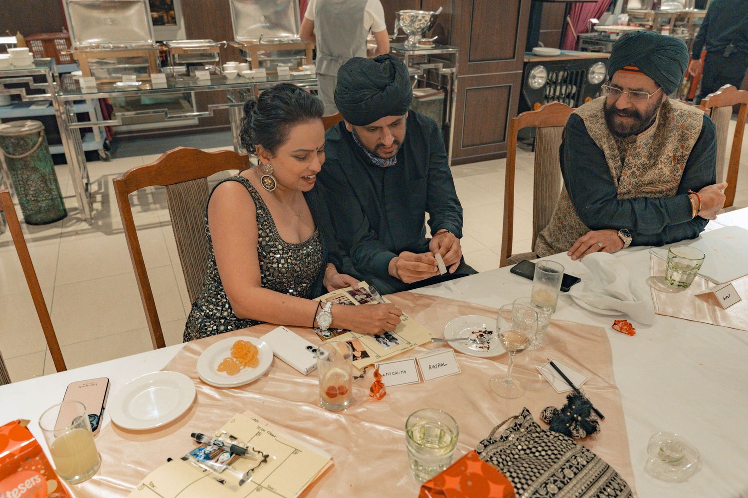 A group gathers around a restaurant table examining menus and enjoying appetizers in an elegant dining setting.