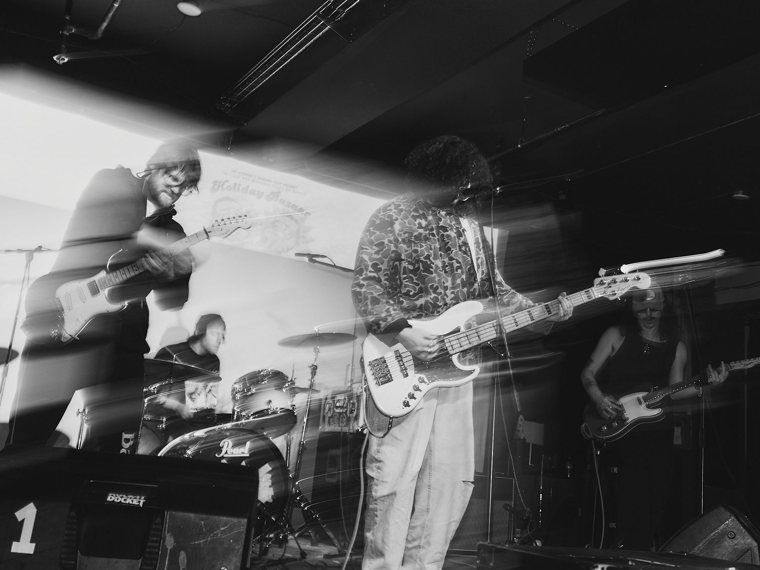 Black and white concert photography showing musicians performing with guitars in sequential shots.