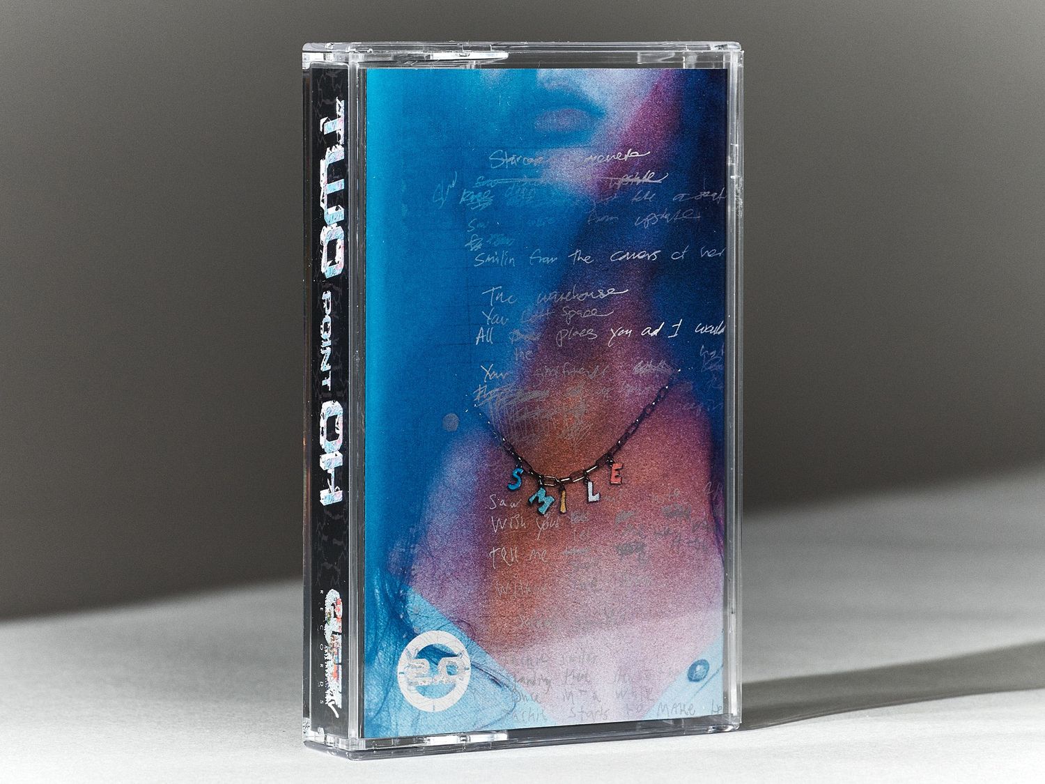 Row of clear plastic CD cases displaying abstract blue and pink album artwork.