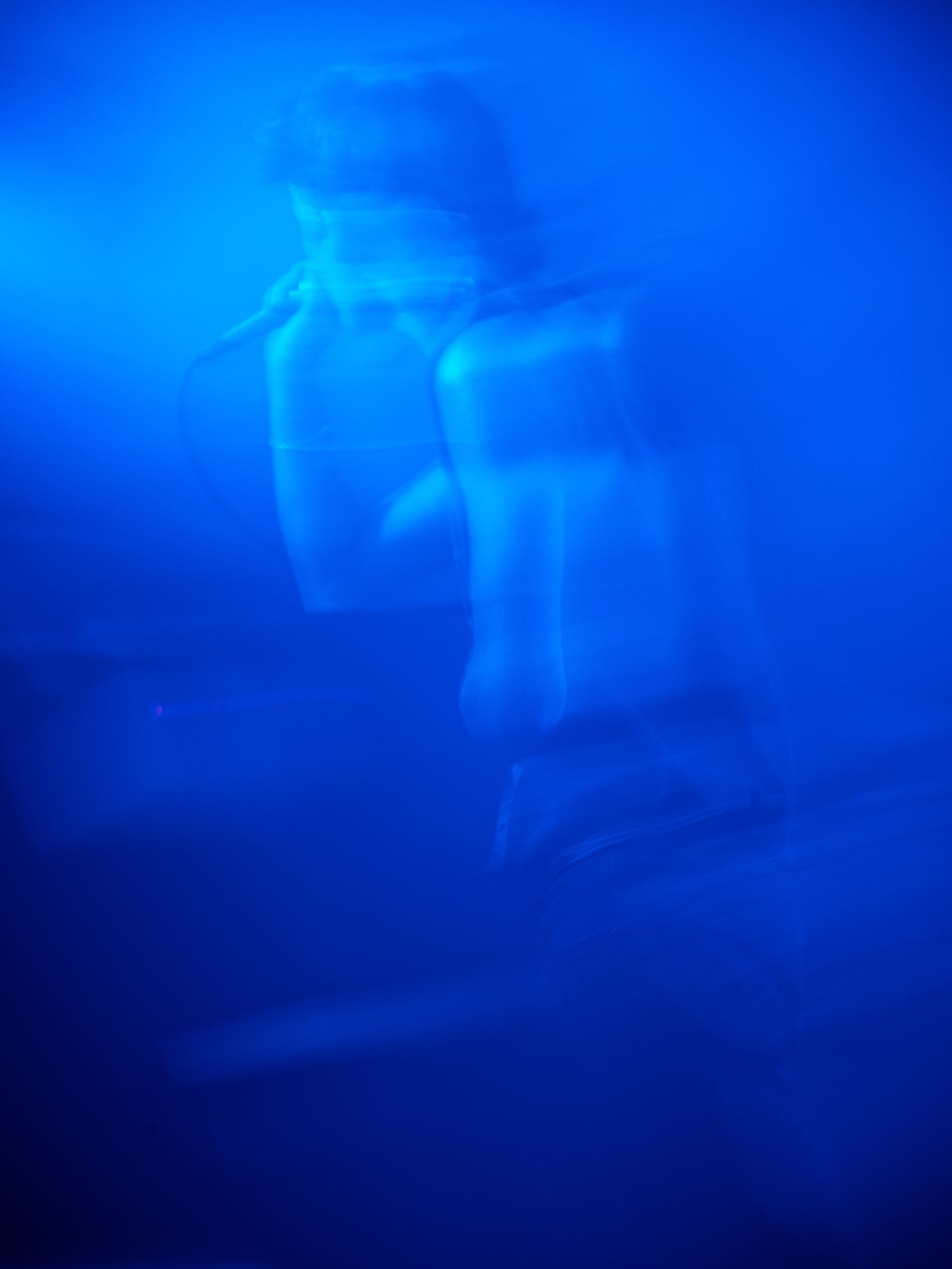 Abstract underwater blue photographs showing ethereal light patterns and movement.