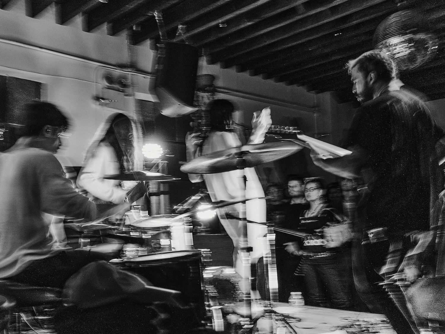 Dynamic black and white photography capturing blurred movement under industrial lighting.