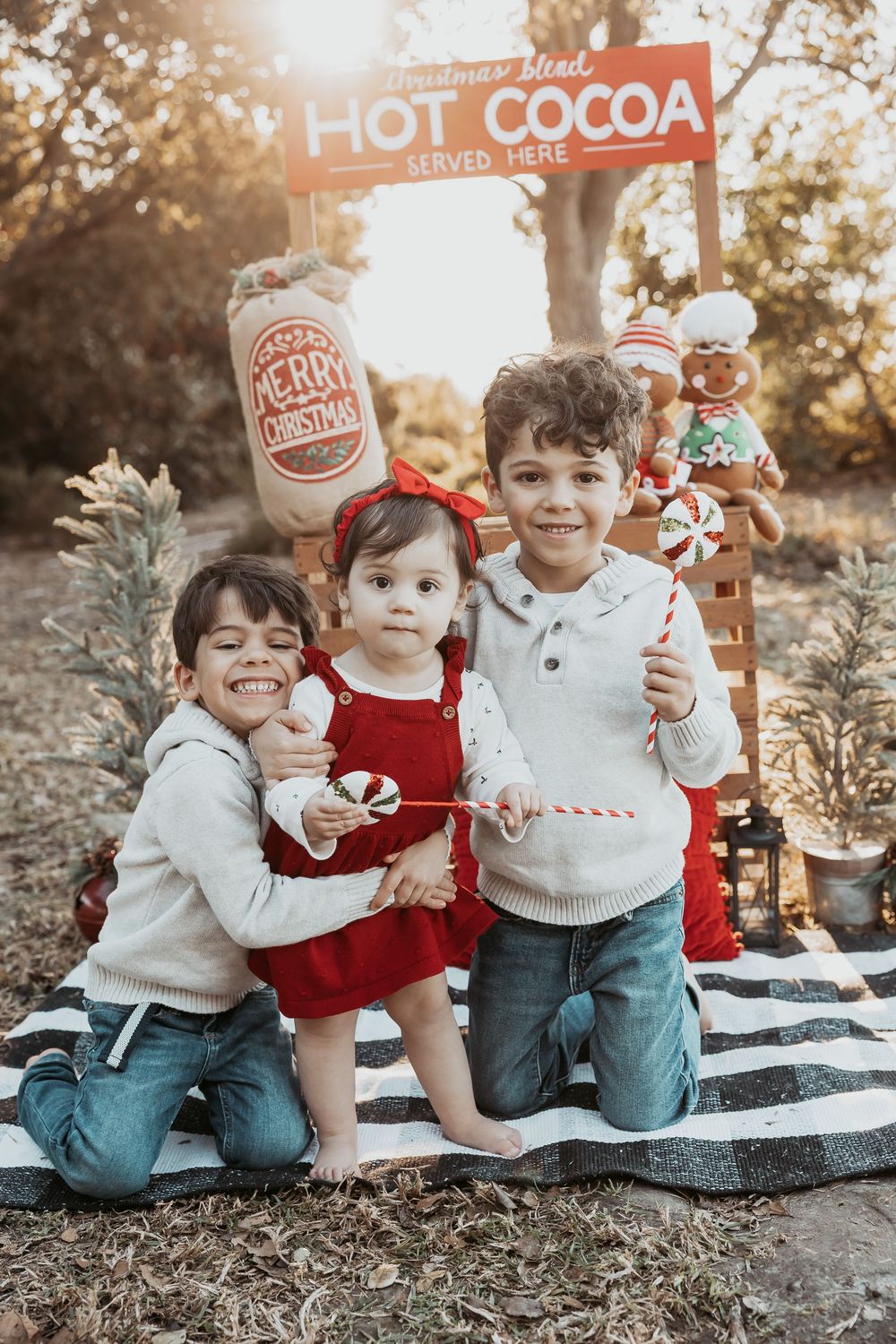 Children gather around a hot cocoa stand with candy canes and festive decorations in a warm autumn setting.