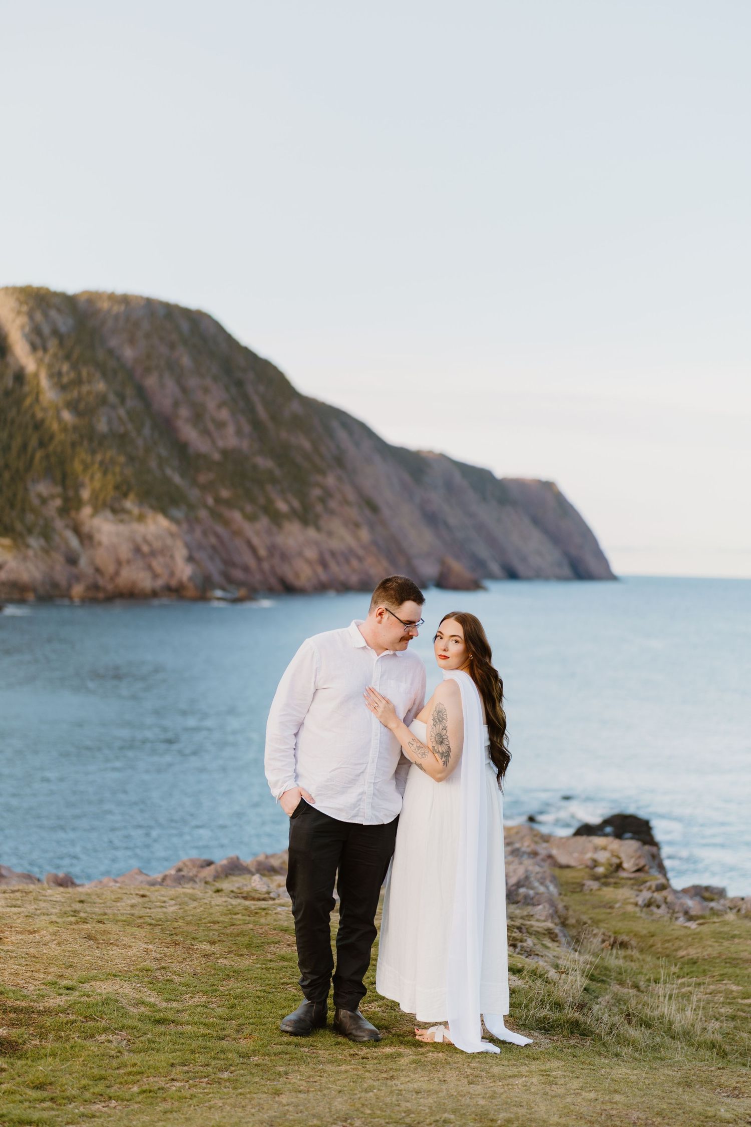 A tender moment between two people in a lush forest setting during golden hour.
