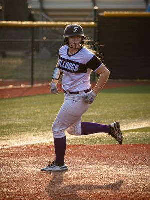 High school softball player from Fayetteville, Arkansas running to a base during a game.