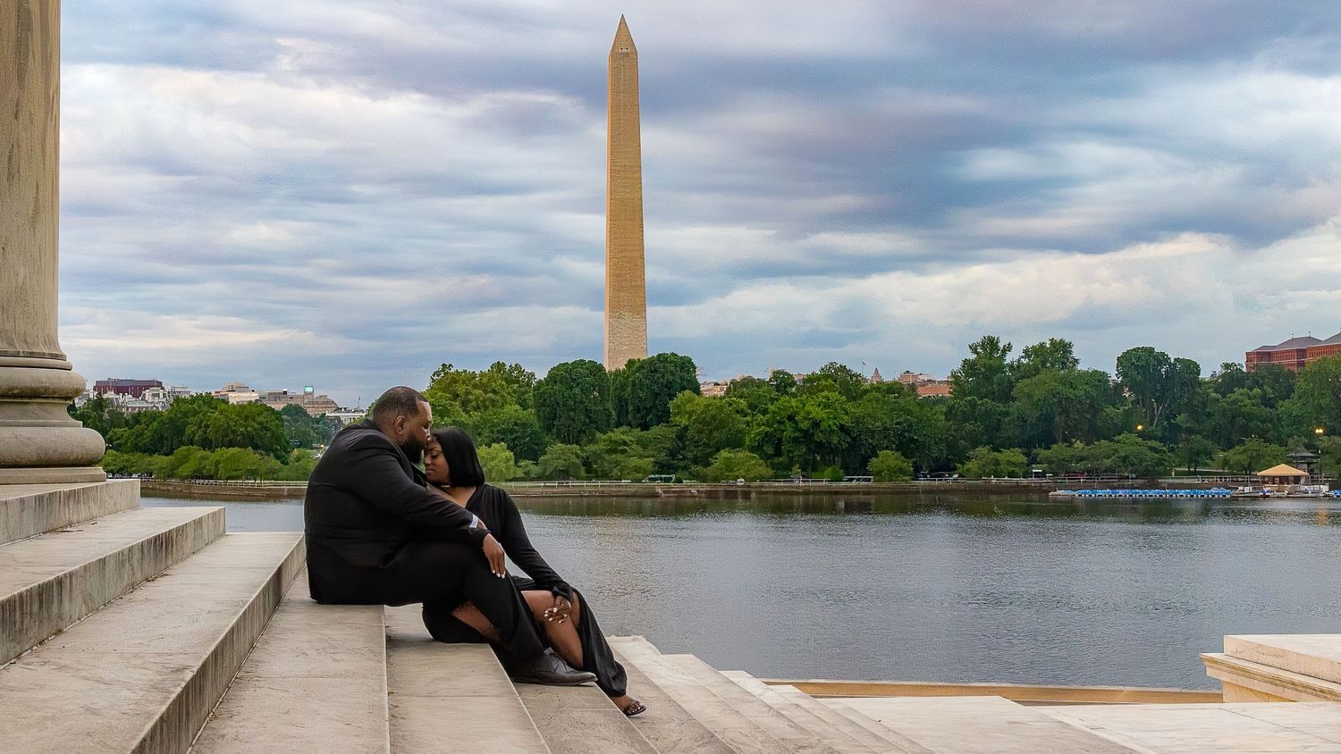 Panoramic view of the Washington Monument and Jefferson Memorial along the Tidal Basin in Washington DC under cloudy skies.