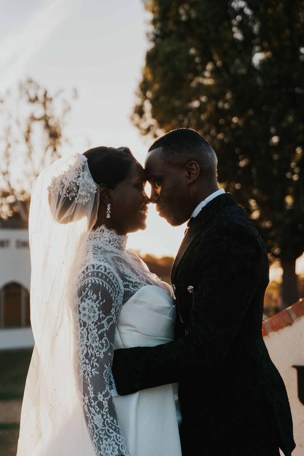 Romantic silhouettes of newlyweds share tender moments at sunset during their wedding photoshoot.