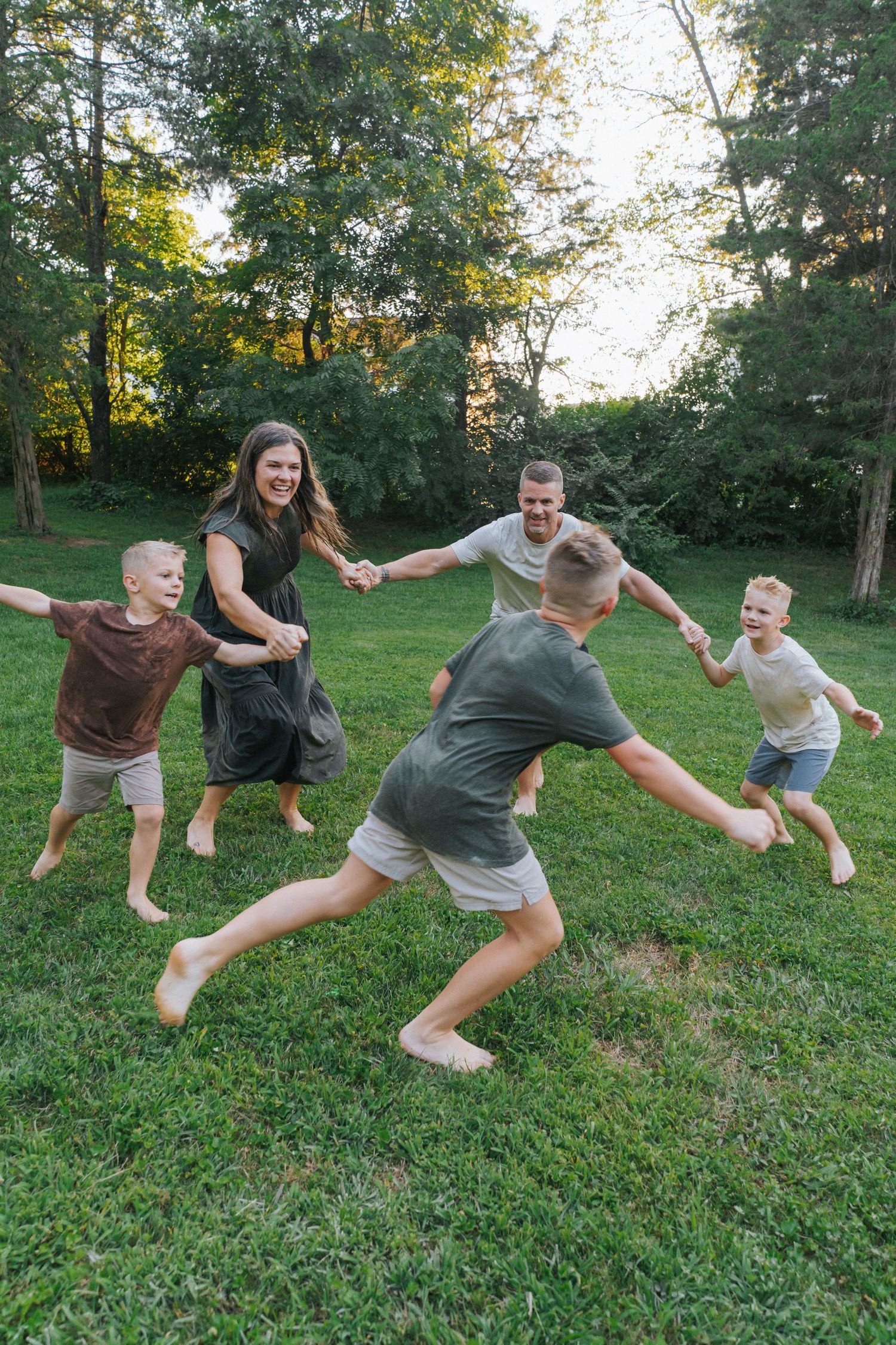 Two people playfully pose in a sequence of action shots on a grassy hillside during golden hour.