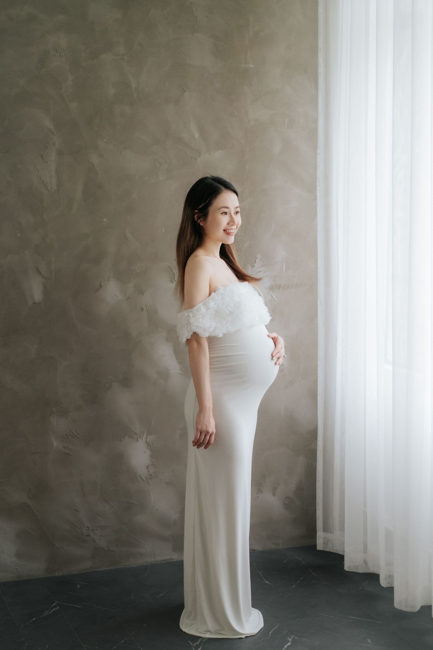 A cake smash photography session featuring white balloons, greenery decorations, and rustic wooden elements.