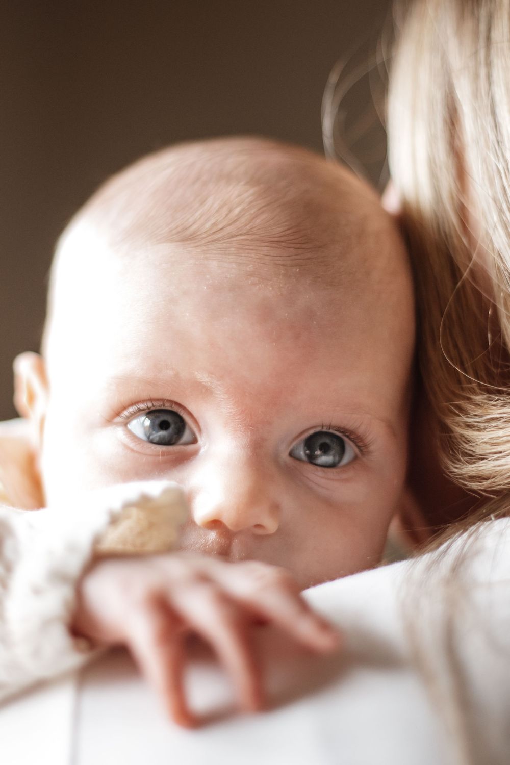Close up portrait of a baby with bright blue eyes looking directly at the camera.