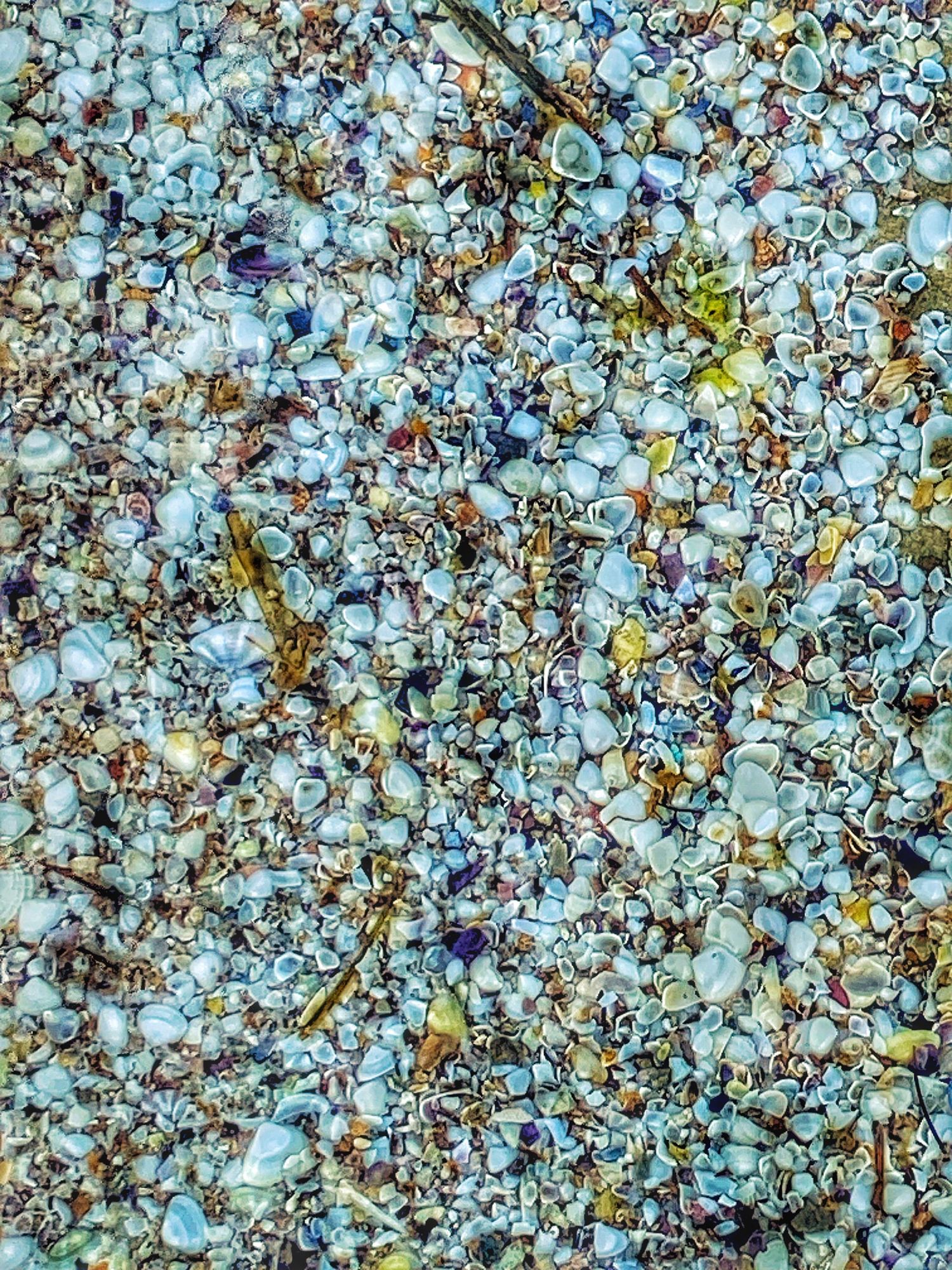 Abstract kaleidoscopic pattern with blue, brown and yellow fragments creating a mesmerizing mosaic against a light background.