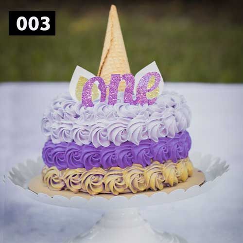 Purple and cream unicorn themed cake with sparkly 'one' topper and ice cream cone decoration.