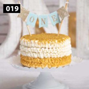 Yellow and white decorated cake with bunting flags on top.