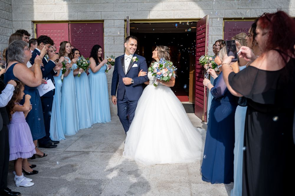 Wedding party dances together in a reception hall with navy blue and light blue color scheme.